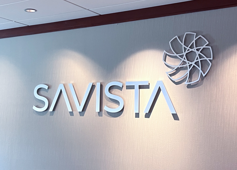 Silver signage of the Savista logo on the wall at the Savista office