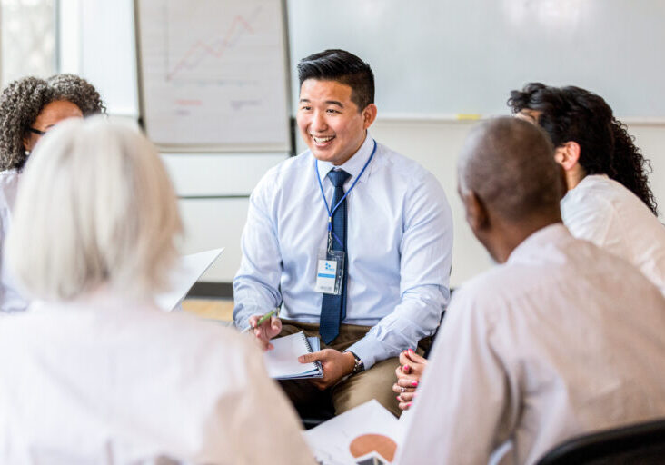 Confident Asian businessman smiles during meeting with healthcare professionals and people from hospital administration