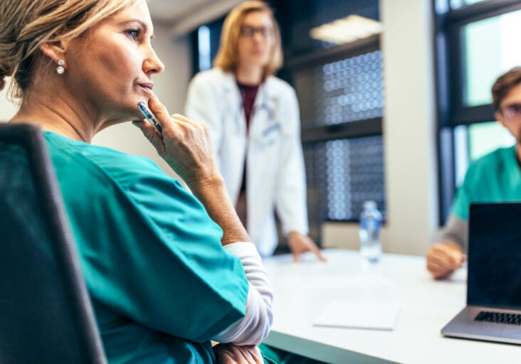 A female medical professional listening in a meeting